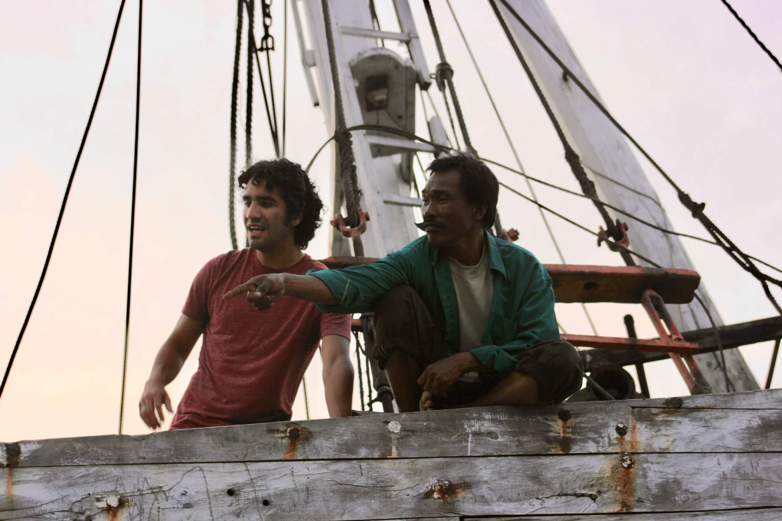 Juliano (left) talking with a fisher (right) during a trip to Indonesia on a sailboat